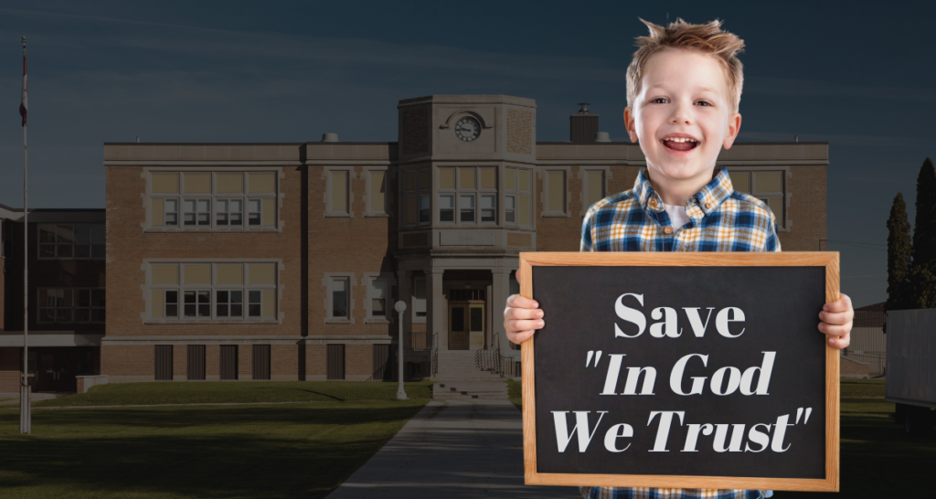 A child holding a blackboard with the words "Save 'In God We Trust'" against a school backdrop.